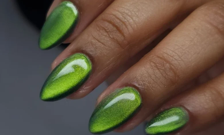 Unhas decoradas com efeito cat eye verde e acabamento brilhante.