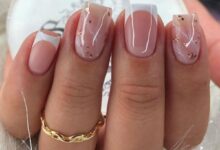 Unhas com decoração moderna em tons neutros, combinação de francesinha e detalhes metálicos em dourado