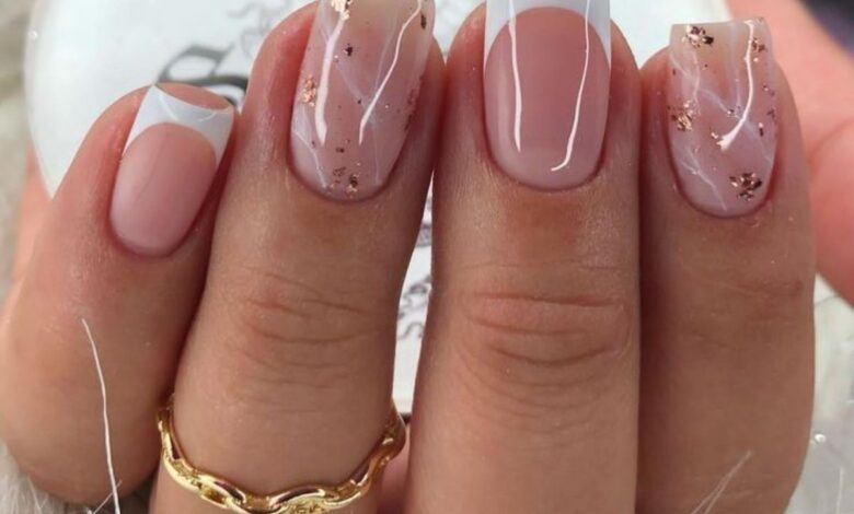 Unhas com decoração moderna em tons neutros, combinação de francesinha e detalhes metálicos em dourado