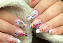 Unhas decoradas com bandeirinhas coloridas, balões e detalhes brilhantes para a Festa Junina.