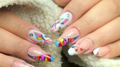 Unhas decoradas com bandeirinhas coloridas, balões e detalhes brilhantes para a Festa Junina.