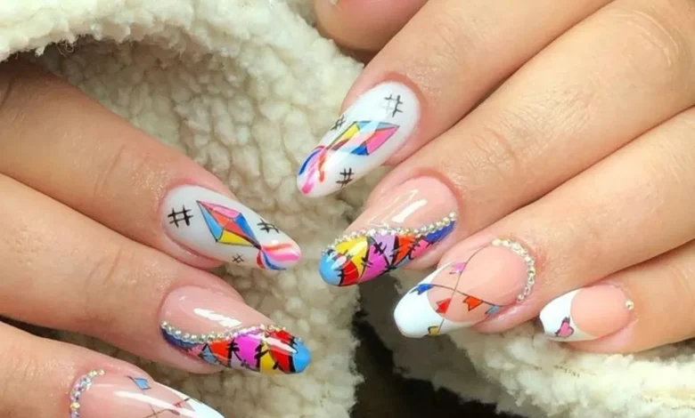 Unhas decoradas com bandeirinhas coloridas, balÔes e detalhes brilhantes para a Festa Junina.