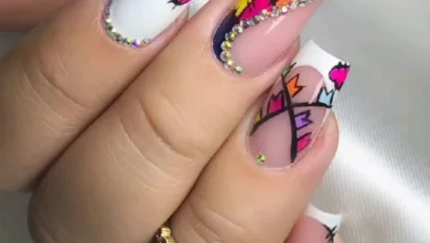 Unhas decoradas coloridas e modernas com pedras brilhantes, design vibrante e detalhes geométricos.