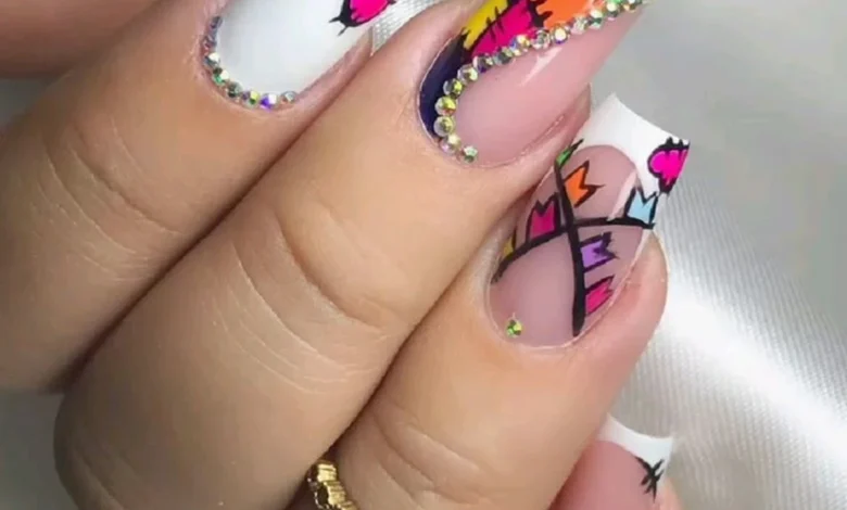 Unhas decoradas coloridas e modernas com pedras brilhantes, design vibrante e detalhes geométricos.