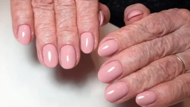 Unhas cuidadas e elegantes em mãos maduras com esmalte rosado