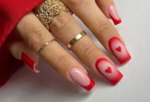 Unhas românticas com decoração em vermelho e detalhes de corações, perfeitas para o Dia dos Namorados.