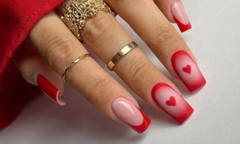 Unhas românticas com decoração em vermelho e detalhes de corações, perfeitas para o Dia dos Namorados.