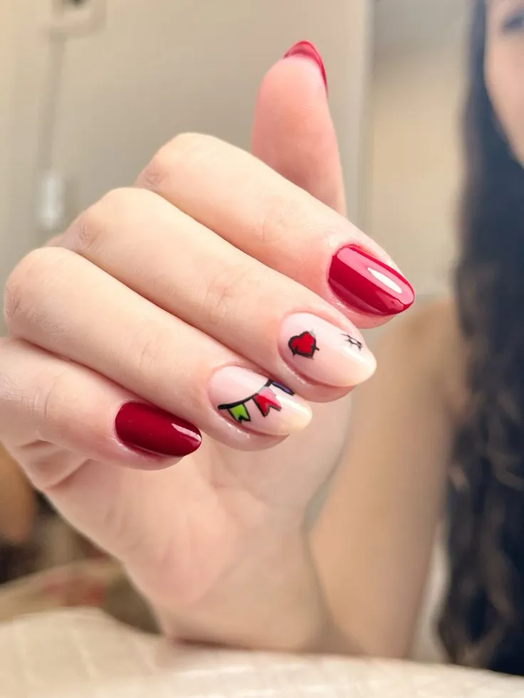 Unhas com esmalte vermelho vibrante e desenhos coloridos de bandeirinhas e coração