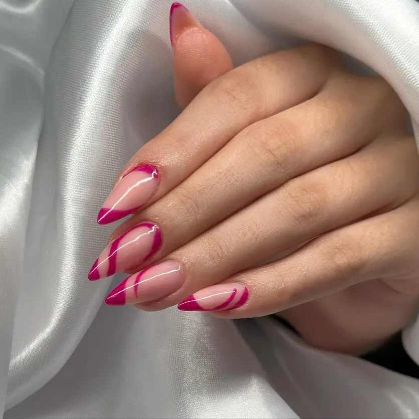 Unhas stiletto com linhas geométricas em rosa.