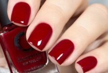 Unhas curtas pintadas com esmalte vermelho profundo, com brilho uniforme e acabamento impecável.