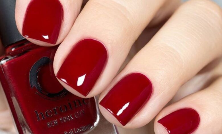 Unhas curtas pintadas com esmalte vermelho profundo, com brilho uniforme e acabamento impecĂĄvel.