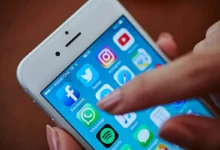 Imagem de celular com ícones de aplicativos populares como WhatsApp, Facebook e Spotify, destacando a tela inicial de um dispositivo