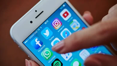 Imagem de celular com ícones de aplicativos populares como WhatsApp, Facebook e Spotify, destacando a tela inicial de um dispositivo