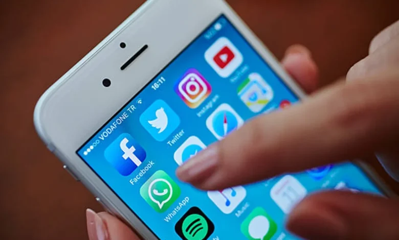 Imagem de celular com Ãcones de aplicativos populares como WhatsApp, Facebook e Spotify, destacando a tela inicial de um dispositivo