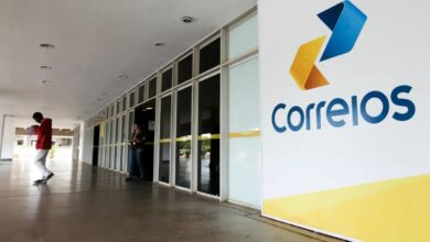 Fachada com logo dos Correios e pessoas circulando
