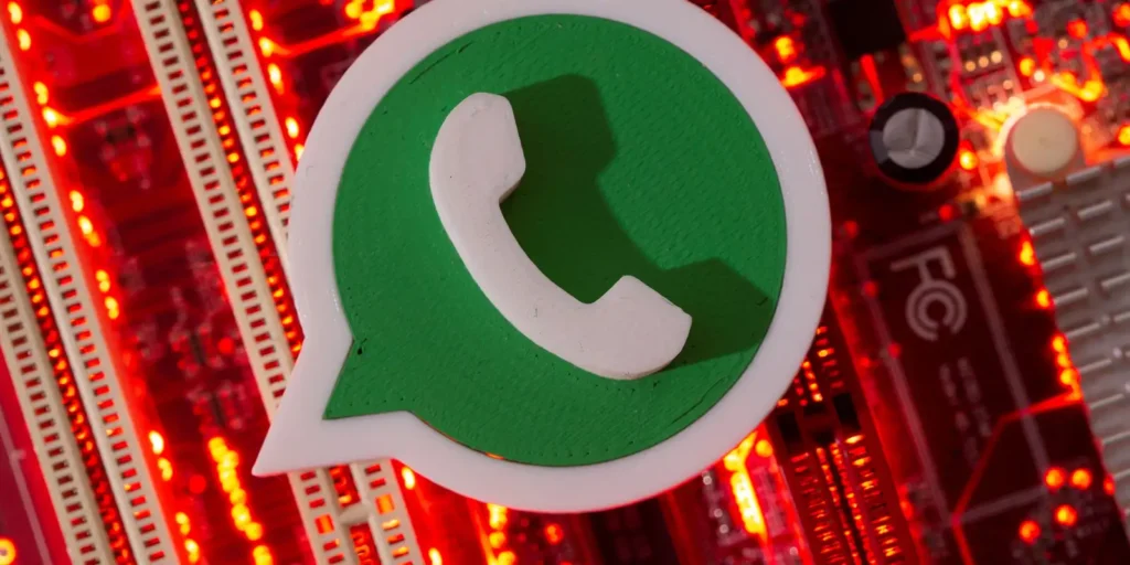 Logo do WhatsApp em destaque sobre placa de circuito com luzes vermelhas