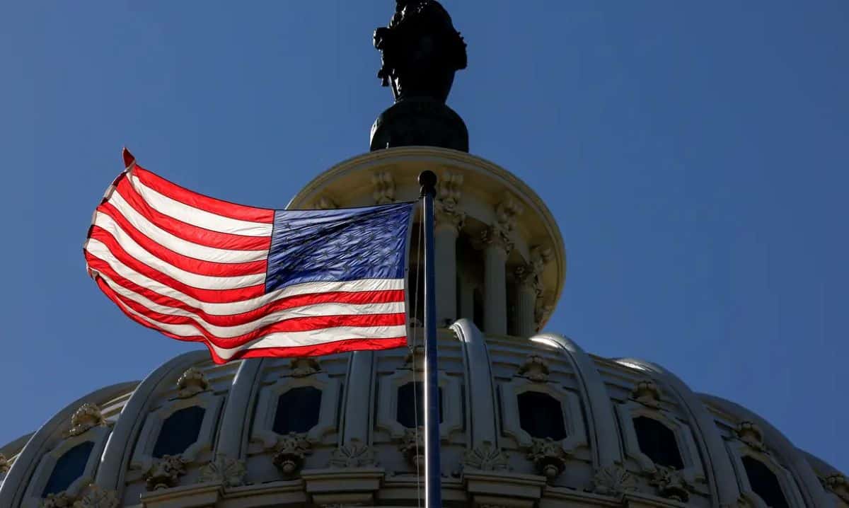 bandeira dos Estados Unidos em frente ao Capitólio sob céu limpo
