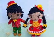 Bonecos de amigurumi caipiras com roupas coloridas, feitos em crochê, representando casal típico de festa junina.
