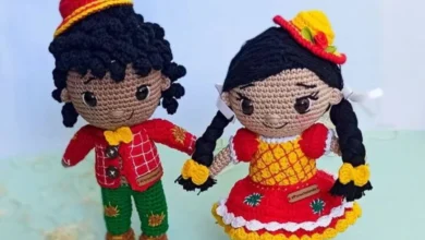 Bonecos de amigurumi caipiras com roupas coloridas, feitos em crochê, representando casal típico de festa junina.