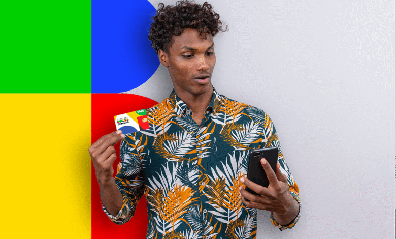 Homem surpreso segura cartão do Bolsa Família enquanto olha o celular.