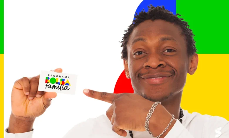 Homem segurando cartão do Bolsa Família, sorrindo e apontando para ele com fundo colorido.