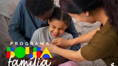Família recebendo apoio do programa Bolsa Família, com mãe, pai e filha sorrindo em casa.