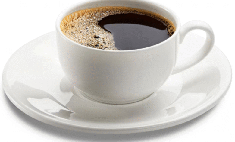 Xícara branca com café preto quente servida em pires sobre fundo claro