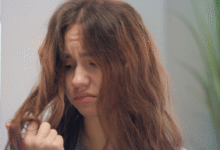Mulher com cabelo ondulado e frizz, demonstrando insatisfação com os fios arrepiados.