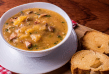 Caldo de mandioquinha com linguiça servido com fatias de pão