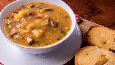 Caldo de mandioquinha com linguiça servido com fatias de pão