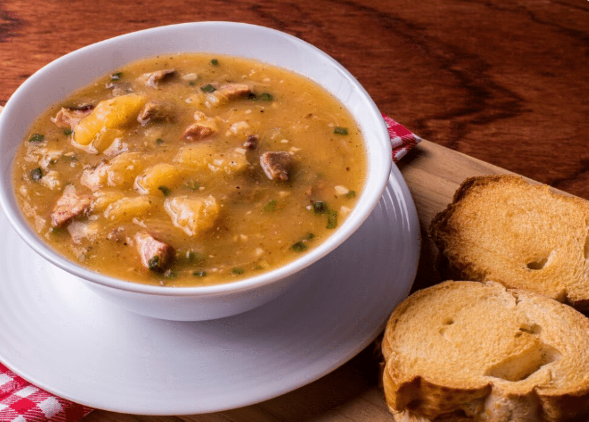 Caldo de mandioquinha com linguiça servido com fatias de pão