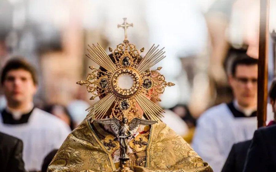 Processão religiosa de Corpus Christi com a exposição do Santíssimo Sacramento, destacando o momento de fé durante o feriado.