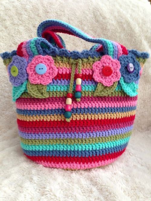  Mochila de crochê infantil com listras coloridas e flores aplicadas