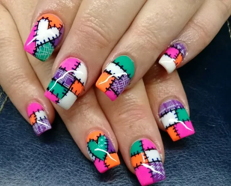 Unhas com estampa de retalhos no estilo patchwork, combinando cores vibrantes e costuras decorativas, perfeitas para um visual criativo e festivo.