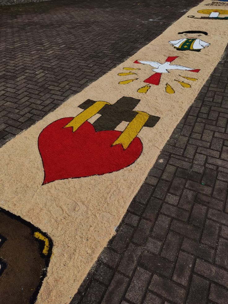 Tapete decorativo religioso com símbolos do Espírito Santo, sacerdote e coração para festa de Corpus Christi.