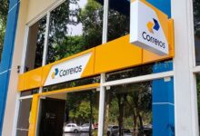 Fachada da agência dos Correios, com o logo visível, refletindo a modernização nos serviços postais.
