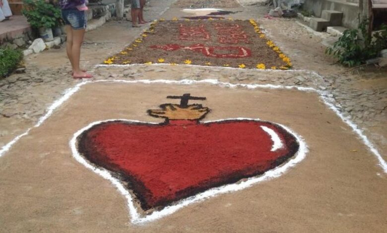 apete artístico religioso com coração flamejante e cruz durante celebração de Corpus Christi.