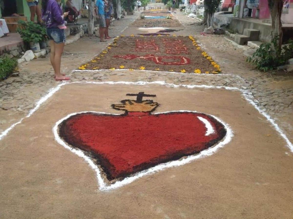 apete artístico religioso com coração flamejante e cruz durante celebração de Corpus Christi.
