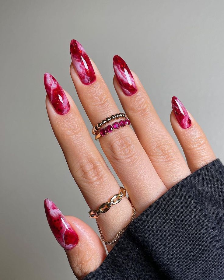 Unhas redondas com decoração marmorizada em tons de vermelho e branco