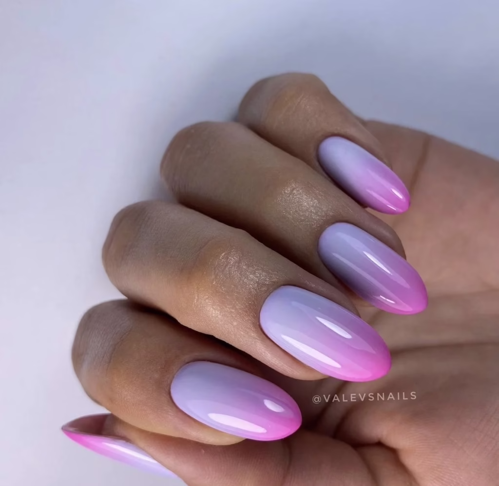 Unhas ombré pastel de rosa e lilás criando um efeito suave e elegante