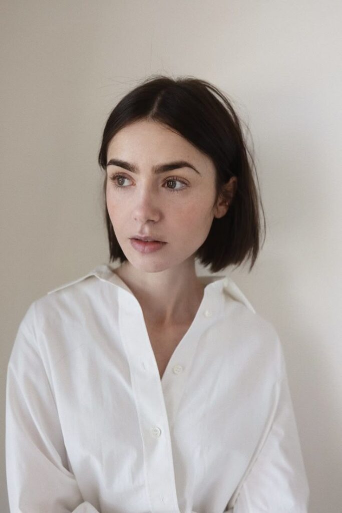 Mulher com corte de cabelo blunt bob clássico e camisa branca