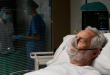 Paciente idoso em hospital recebendo oxigênio por máscara, representando o aumento dos casos de síndrome respiratória aguda grave no país.
