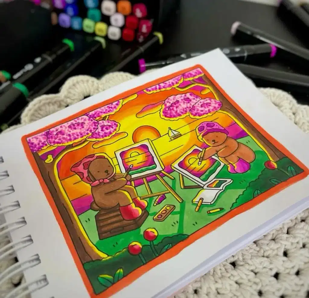 Bobbie Goods: A Arte Terapêutica de Colorir para Alívio do Estresse Ilustração colorida de dois ursinhos pintando ao ar livre, sob flores de cerejeira com o pôr do sol ao fundo, representando a importância da arte na redução de estresse.