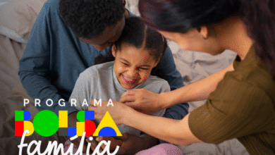 Família sorrindo enquanto mãe e pai ajustam a roupa de criança, com o texto do programa Bolsa Família em destaque.
