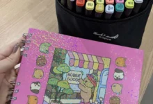 Canetinhas coloridas e caderno com capa de Bobbie Goods em estilo fofo