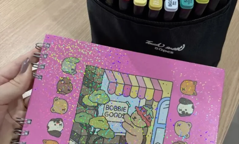 Canetinhas coloridas e caderno com capa de Bobbie Goods em estilo fofo