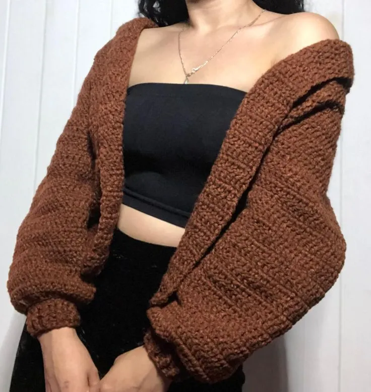 Cardigan de crochê em tom marrom, com mangas largas, perfeito para looks descontraídos e estilosos.