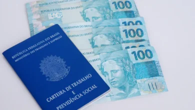 Carteira de Trabalho e notas de 100 reais representando direitos trabalhistas