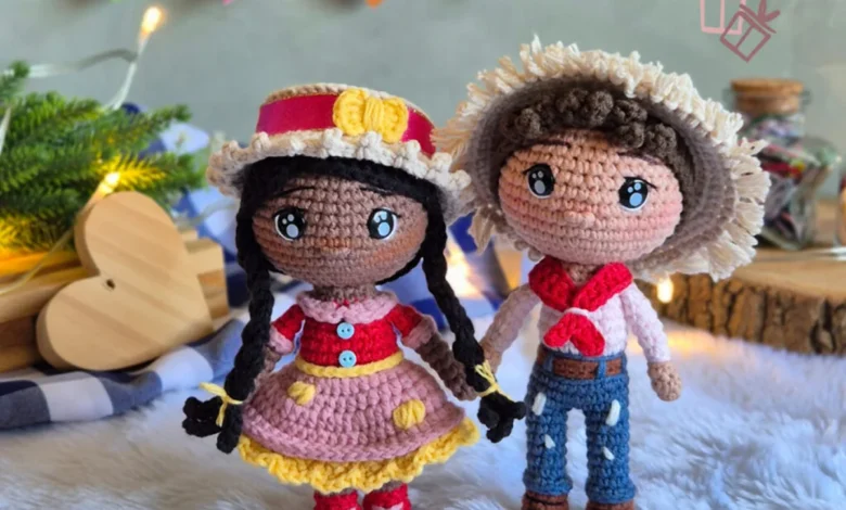 Casal de bonecos amigurumi em estilo junino com roupas tÃpicas e decoração festiva ao fundo