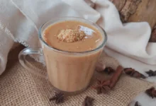 Copo de chá de amendoim cremoso decorado com amendoim triturado, com fundo de decoração junina.